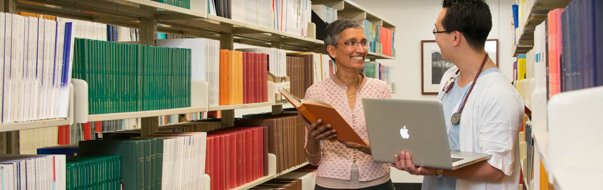 A librarian helping a health professional to locate a book.