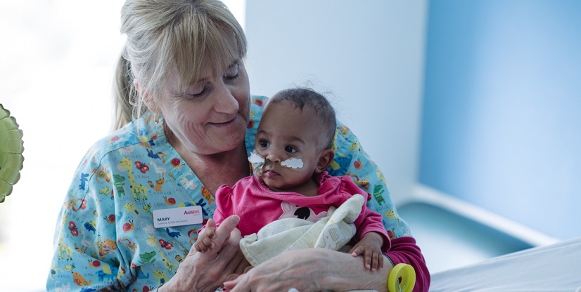 Paediatric nurse holding baby