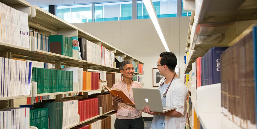 A librarian helping a health professional to locate a book.