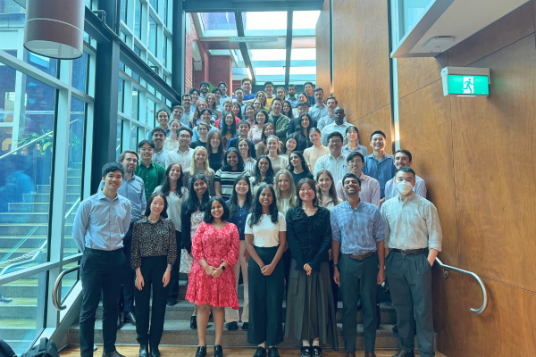 65 medical interns standing on stairs smiling at camera