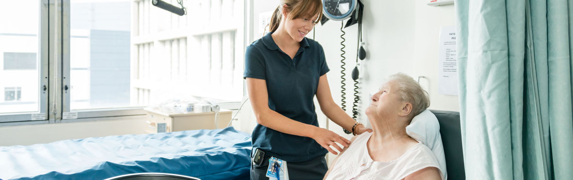 A nurse checks on a patient in the cancer ward
