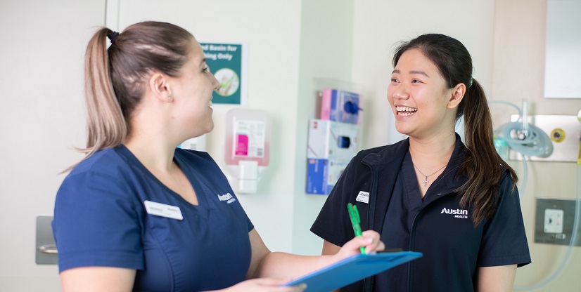 Two smiling Austin Health nurses, one is holding a pen and a clipboard